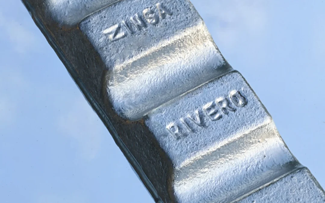 Primer plano de lingotes de zinc con impresiones visibles y textura.